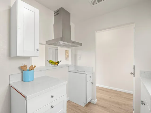 a kitchen with stainless steel appliances a white stove top oven and a white cabinets