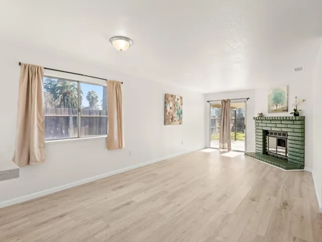wooden floor fireplace and windows in an empty room
