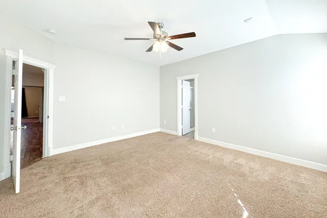 an empty room with closet and ceiling fan