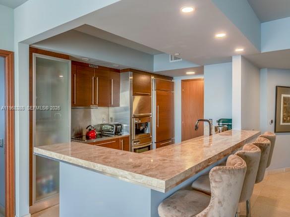 450 Alton Road, Unit 1202 Miami Beach, FL 33139 - Photo 9 of 68 a kitchen with stainless steel appliances granite countertop a sink dishwasher and a refrigerator with wooden floor