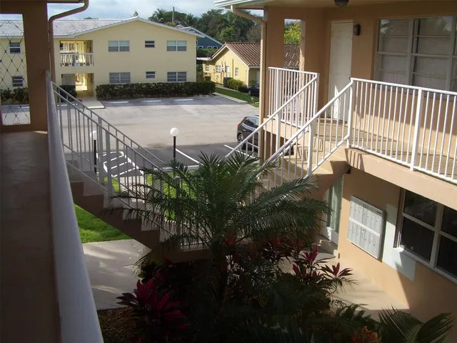 a view of a house with a small yard and potted plants