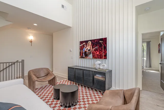 a living room with furniture and a painting on the wall