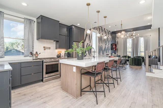 a kitchen with kitchen island granite countertop a table chairs sink and cabinets
