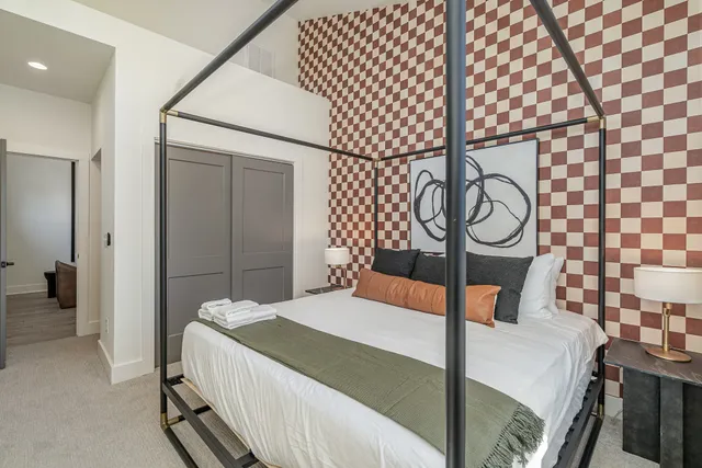 a bedroom with a bed a mirror and lamp