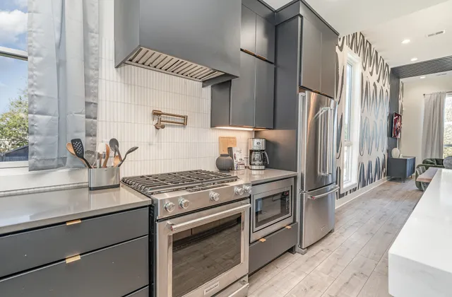 a kitchen with stainless steel appliances granite countertop a stove and a refrigerator
