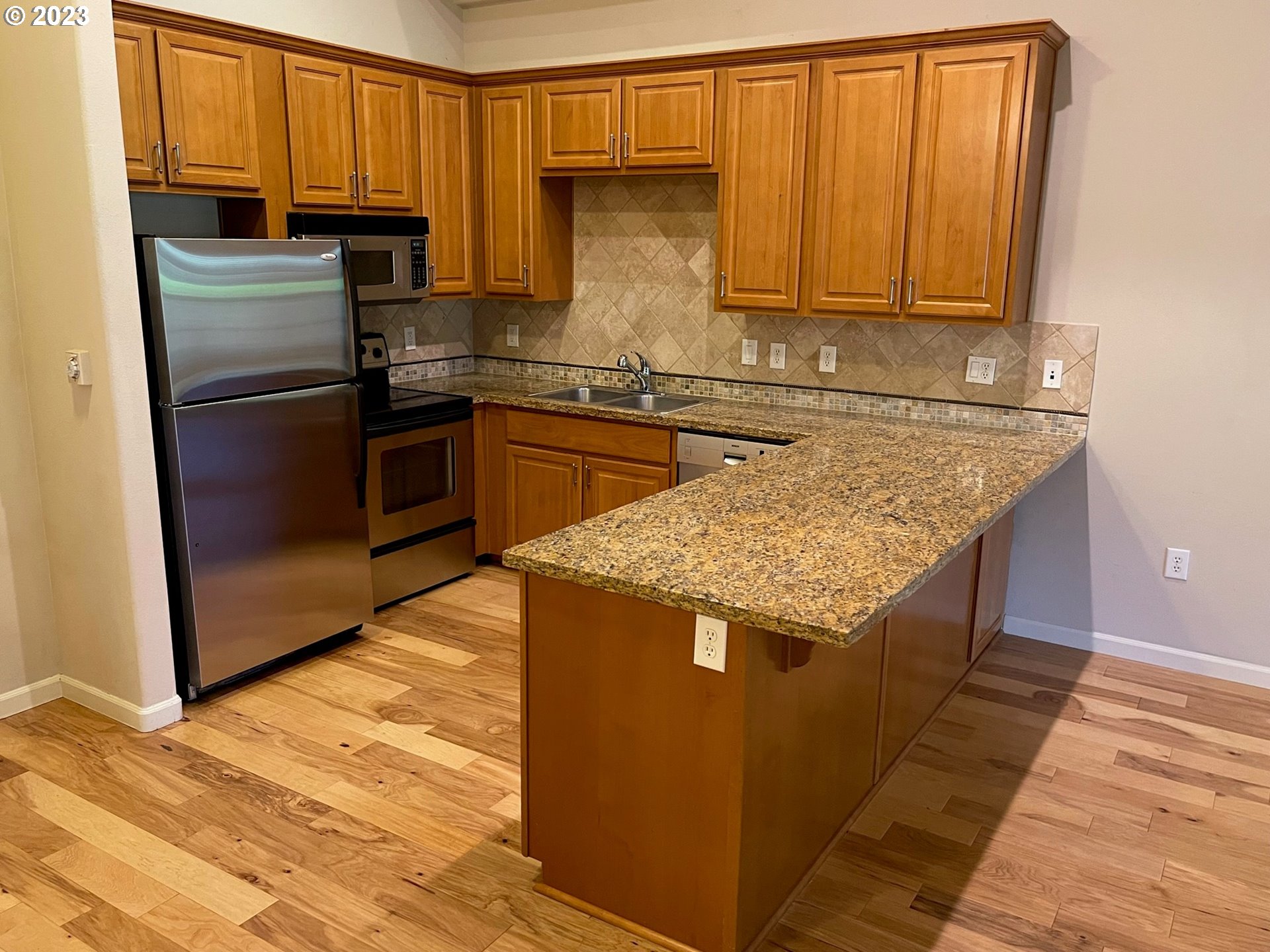 20512 Southwest Roy Rogers Road, Unit 112 Sherwood, OR 97140 - Photo 8 of 18 a kitchen with stainless steel appliances granite countertop a refrigerator and a sink