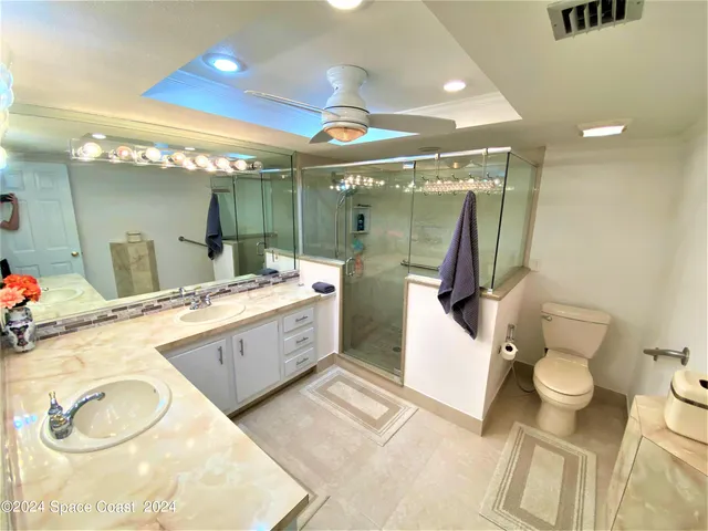 a bathroom with a granite countertop sink toilet and a mirror