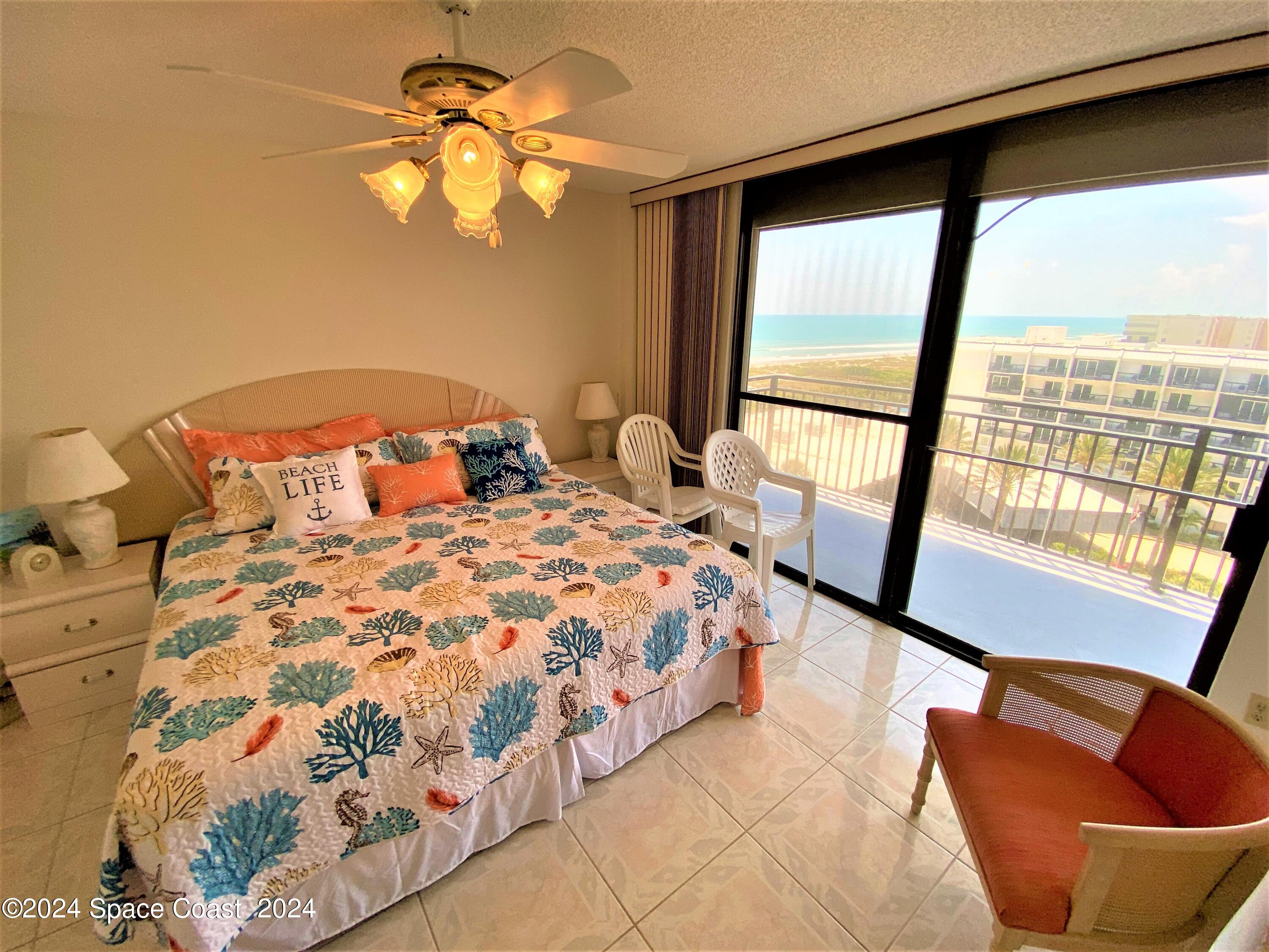 2100 North Atlantic Avenue, Unit 908 Cocoa Beach, FL 32931 - Photo 12 of 17 a bedroom with a large bed and a large window