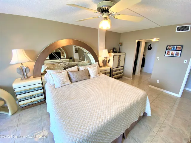 a bedroom with a bed and a ceiling fan