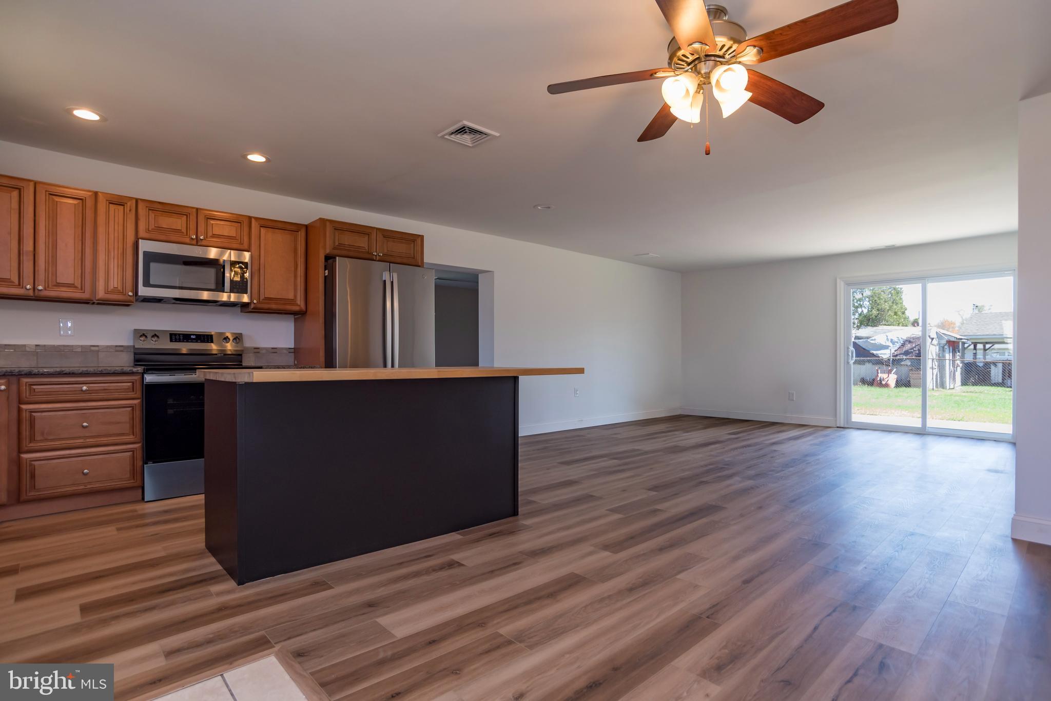 44 Elm Lane Levittown, PA 19054 - Photo 4 of 35 a kitchen with kitchen island wooden floors appliances and cabinets