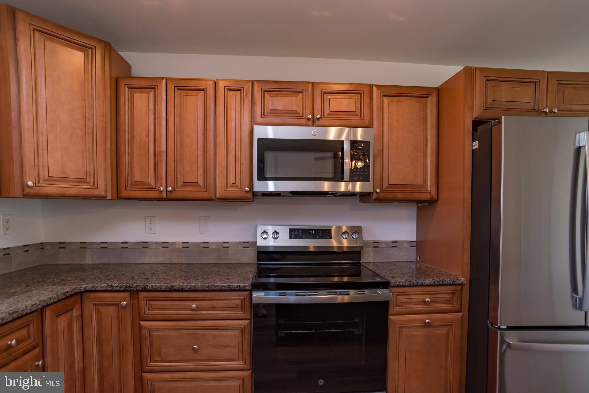 44 Elm Lane Levittown, PA 19054 - Photo 8 of 35 a kitchen with stainless steel appliances granite countertop a refrigerator stove and microwave