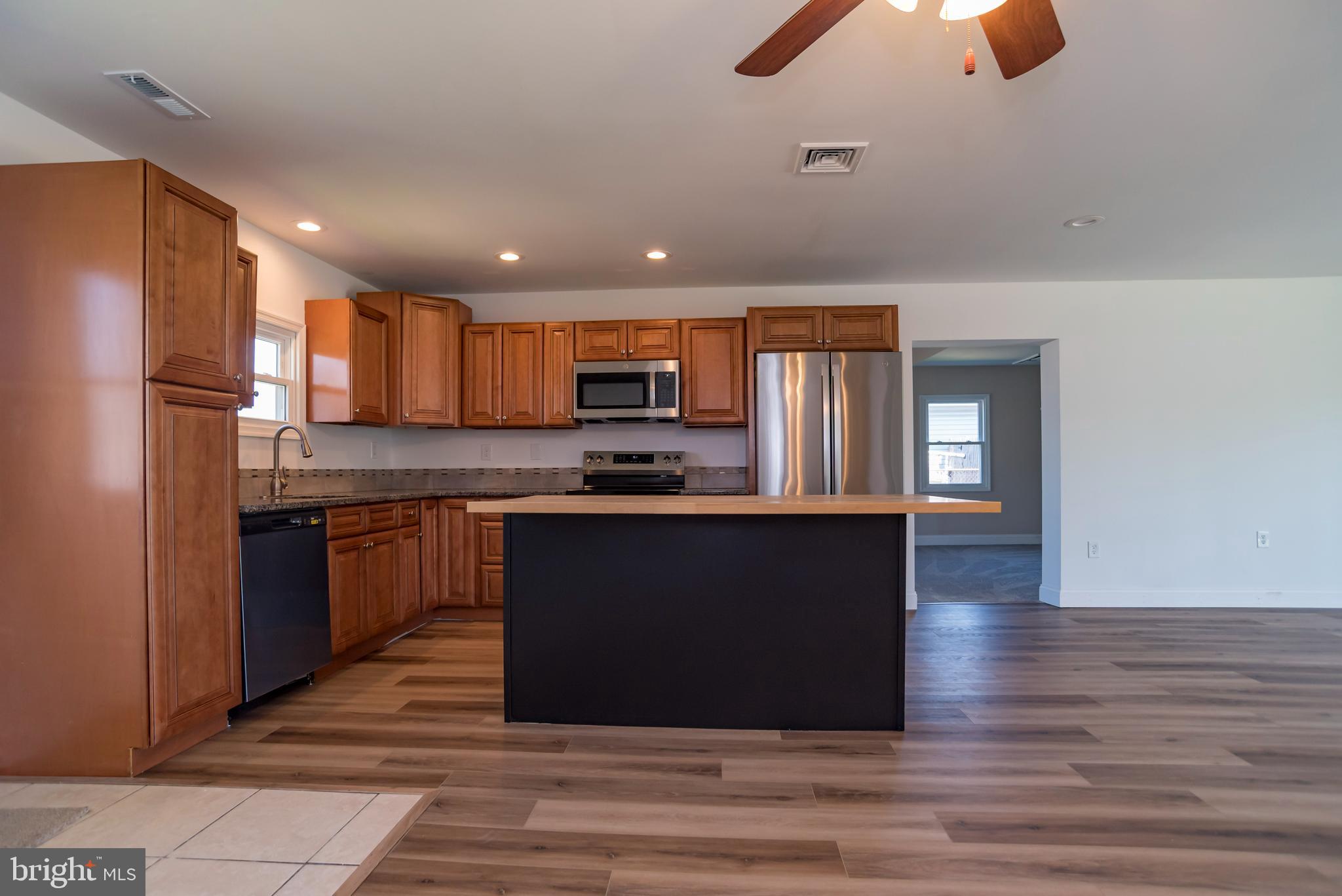 44 Elm Lane Levittown, PA 19054 - Photo 9 of 35 a kitchen with granite countertop a refrigerator and a stove top oven