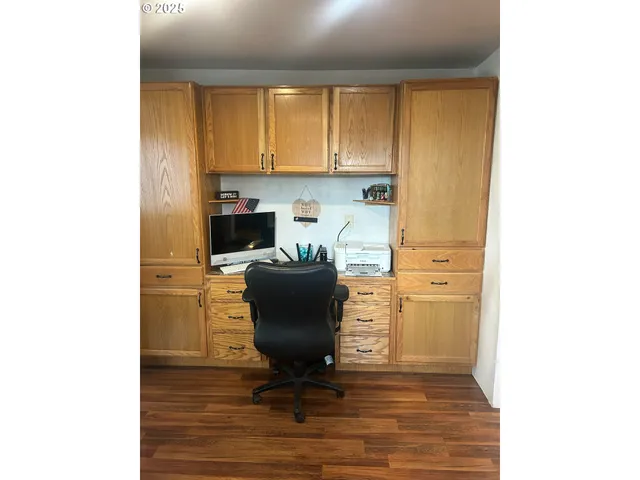a view of a workspace with furniture and a window