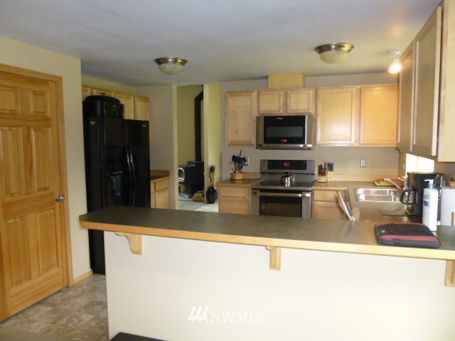 556 Gasman Road Port Angeles, WA 98362 - Photo 15 of 19 a kitchen with stainless steel appliances granite countertop a stove a sink and a refrigerator