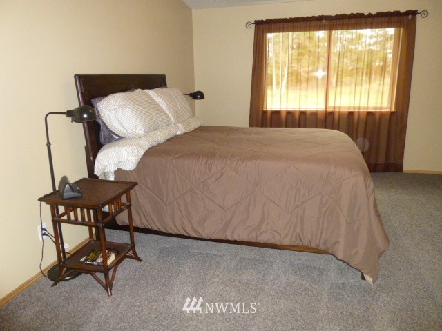 556 Gasman Road Port Angeles, WA 98362 - Photo 6 of 19 a bed sitting in a bedroom next to a window