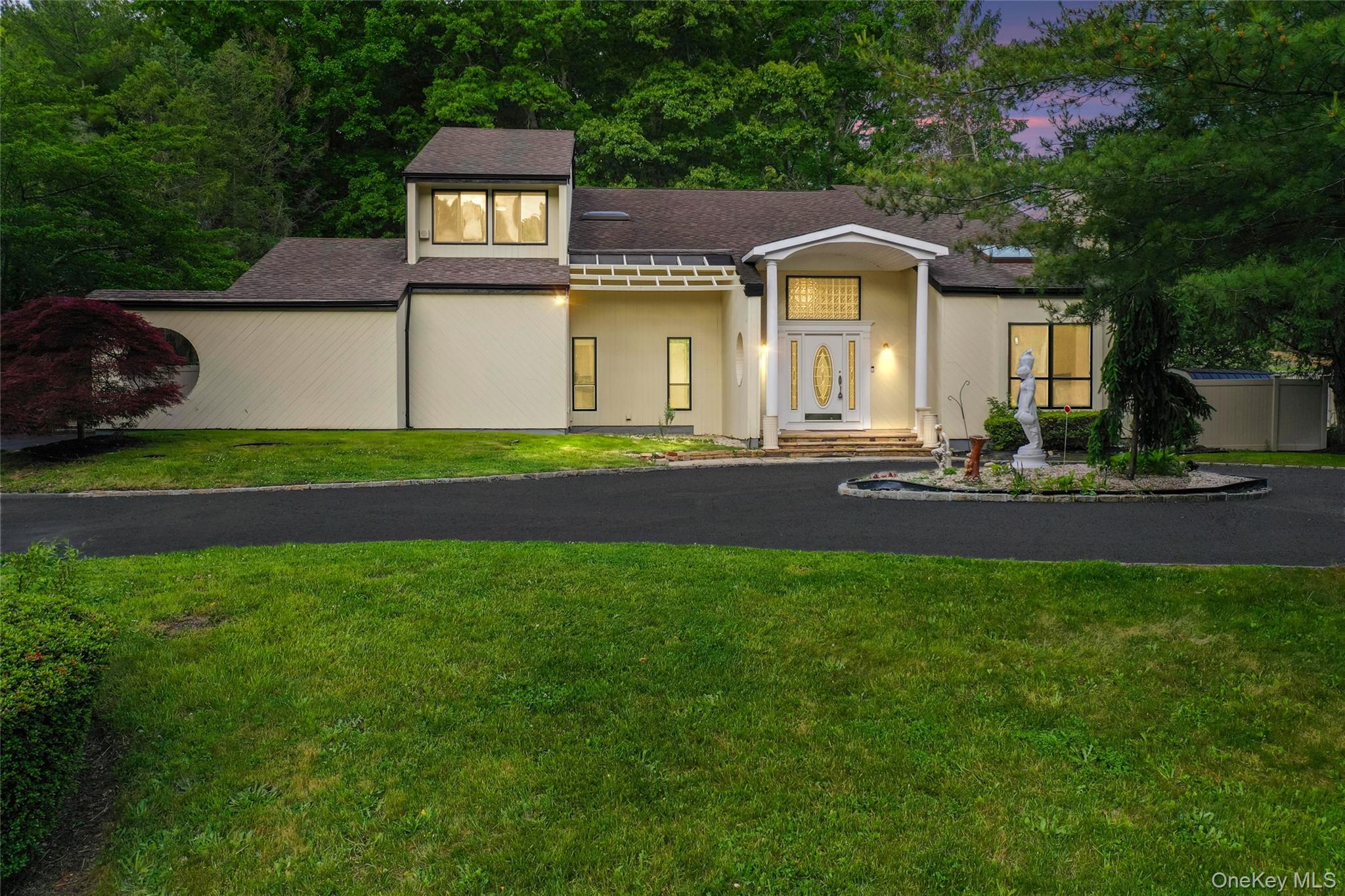 126 Bagatelle Road Melville, NY 11747 - Photo 1 of 50 a front view of a house with a garden and trees