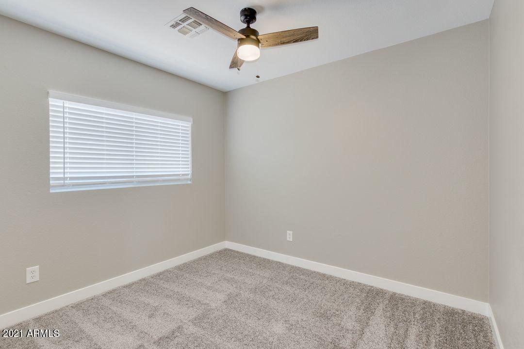 11514 West Larkspur Road El Mirage, AZ 85335 - Photo 12 of 20 an empty room with a window and a fan