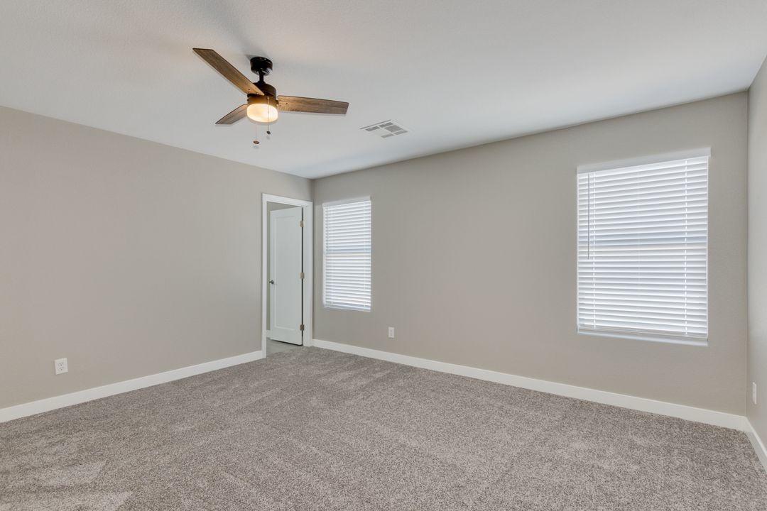 11514 West Larkspur Road El Mirage, AZ 85335 - Photo 16 of 20 a view of a livingroom with a ceiling fan & windows