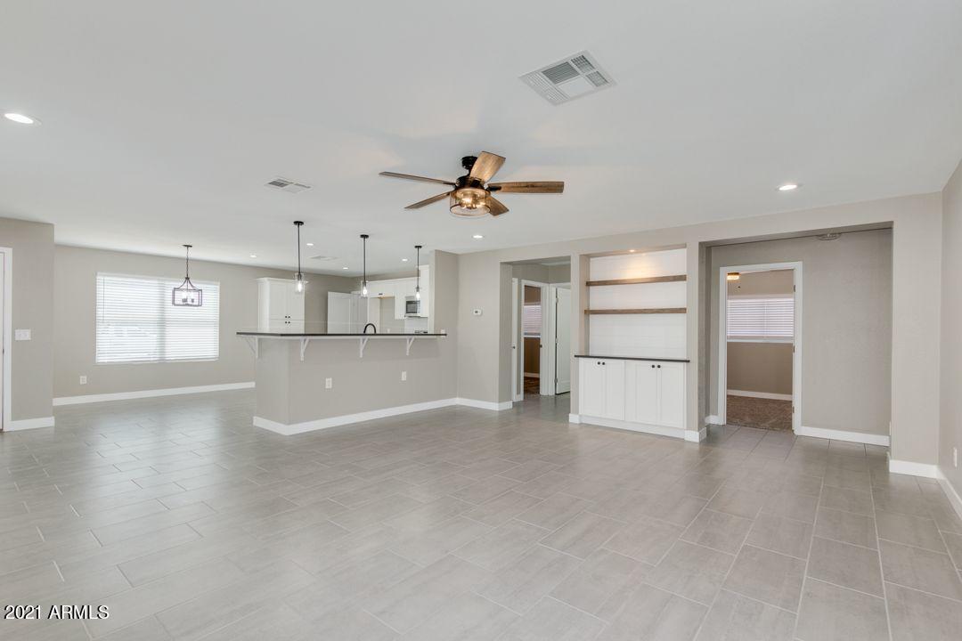 11514 West Larkspur Road El Mirage, AZ 85335 - Photo 5 of 20 a view of a kitchen with wooden floor and a ceiling fan