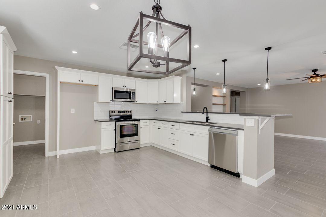 11514 West Larkspur Road El Mirage, AZ 85335 - Photo 8 of 20 a large kitchen with cabinets and stainless steel appliances