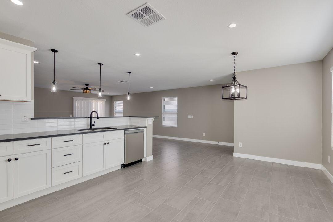 11514 West Larkspur Road El Mirage, AZ 85335 - Photo 10 of 20 a large kitchen with cabinets and wooden floor