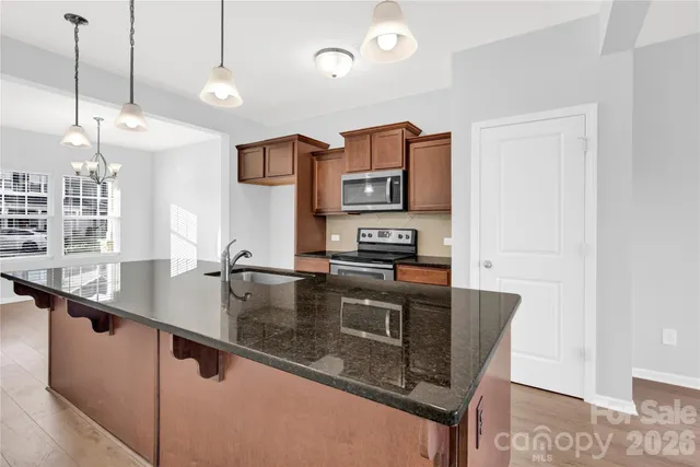 a kitchen with stainless steel appliances granite countertop a sink a stove and a refrigerator