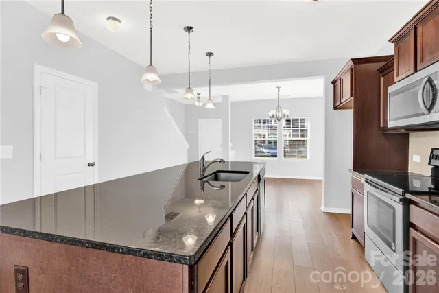 a kitchen with stainless steel appliances granite countertop a sink stove and refrigerator
