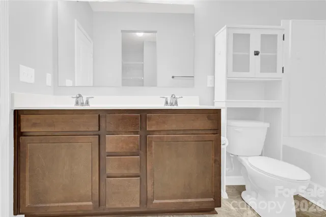 a bathroom with a toilet a sink and mirror