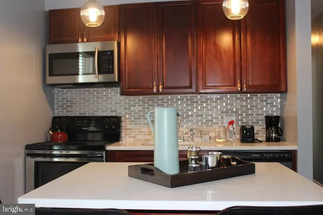 a kitchen with stainless steel appliances a stove a sink and a microwave