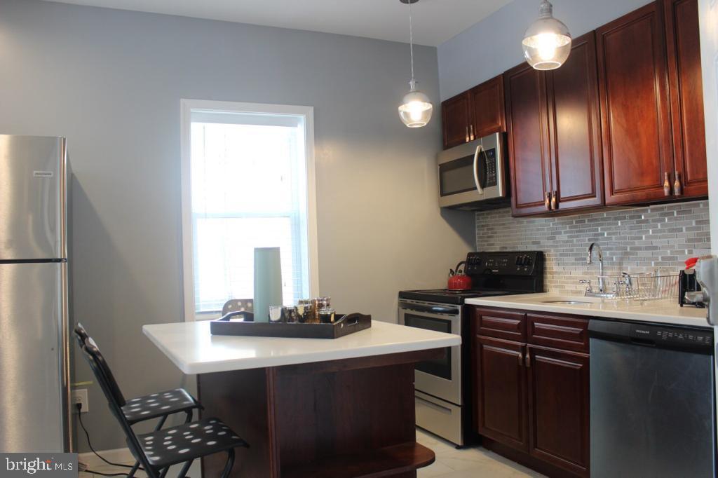 5923 North Broad Street, Unit 1 Philadelphia, PA 19141 - Photo 13 of 25 a kitchen with a sink cabinets and window