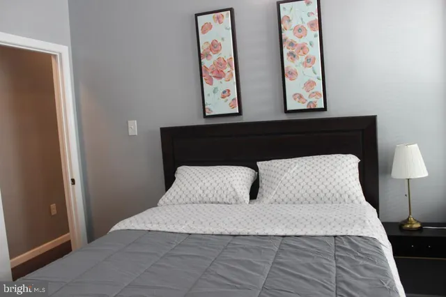 a bedroom with a bed and painting on wall