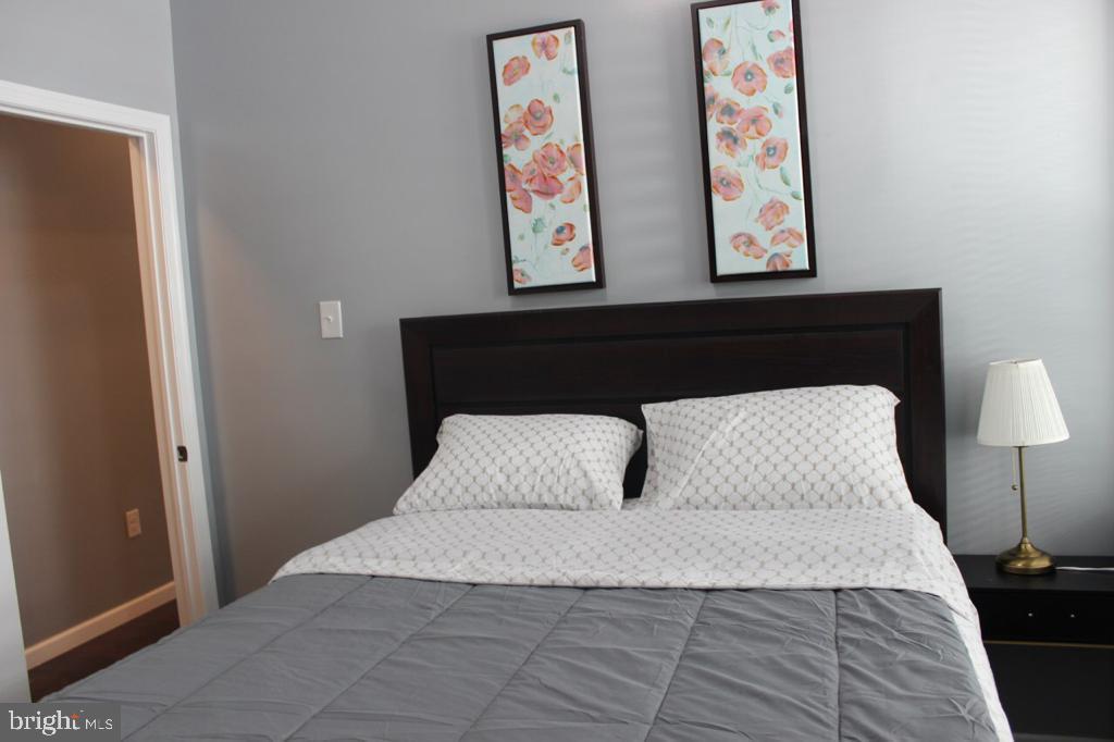 5923 North Broad Street, Unit 1 Philadelphia, PA 19141 - Photo 23 of 25 a bedroom with a bed and painting on wall