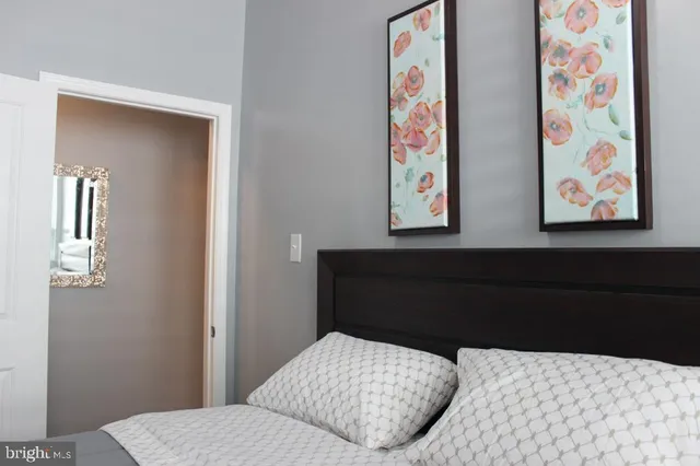 a bedroom with a bed and painting on the wall