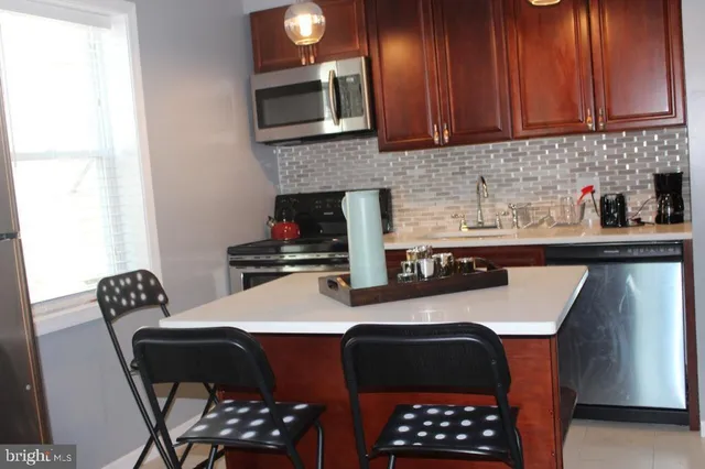 a kitchen with a sink chairs and cabinets