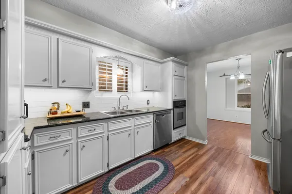 a kitchen with stainless steel appliances granite countertop a refrigerator and a sink