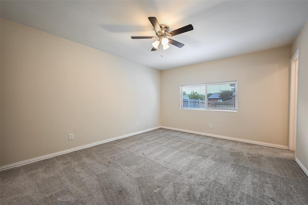 7318 Emory Oak Lane Dallas, TX 75249 - Photo 16 of 28 Spacious room featuring neutral wall tones, grey carpet flooring, and a ceiling fan with integrated lighting