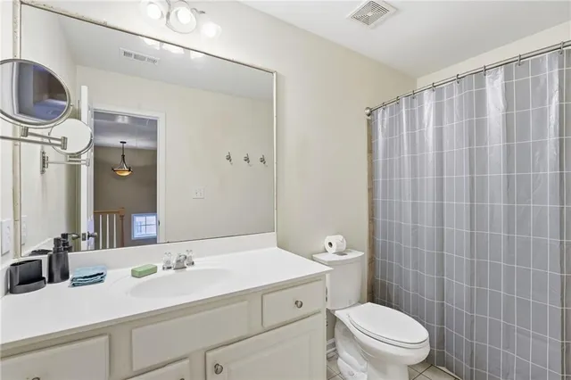 a bathroom with a sink a toilet and shower curtain