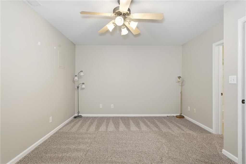 1440 Ferocity Ridge Way Northwest, Unit 17 Kennesaw, GA 30152 - Photo 32 of 42 an empty room with chandelier fan and closet area
