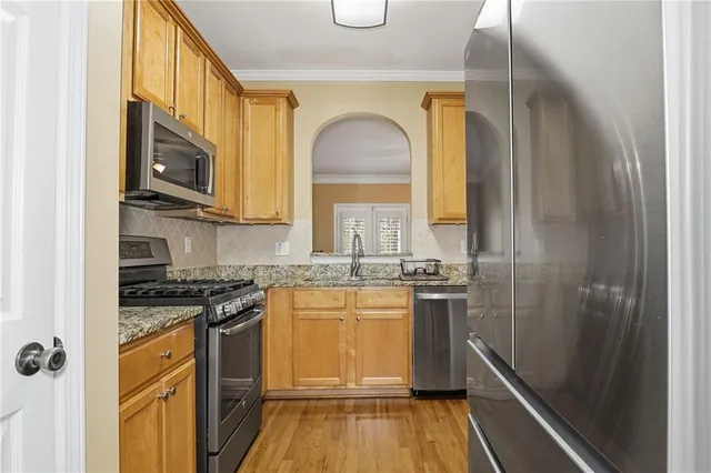 a kitchen with stainless steel appliances granite countertop a stove a sink and a refrigerator