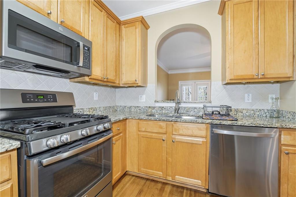 1440 Ferocity Ridge Way Northwest, Unit 17 Kennesaw, GA 30152 - Photo 9 of 42 a kitchen with stainless steel appliances granite countertop a stove a sink and a microwave