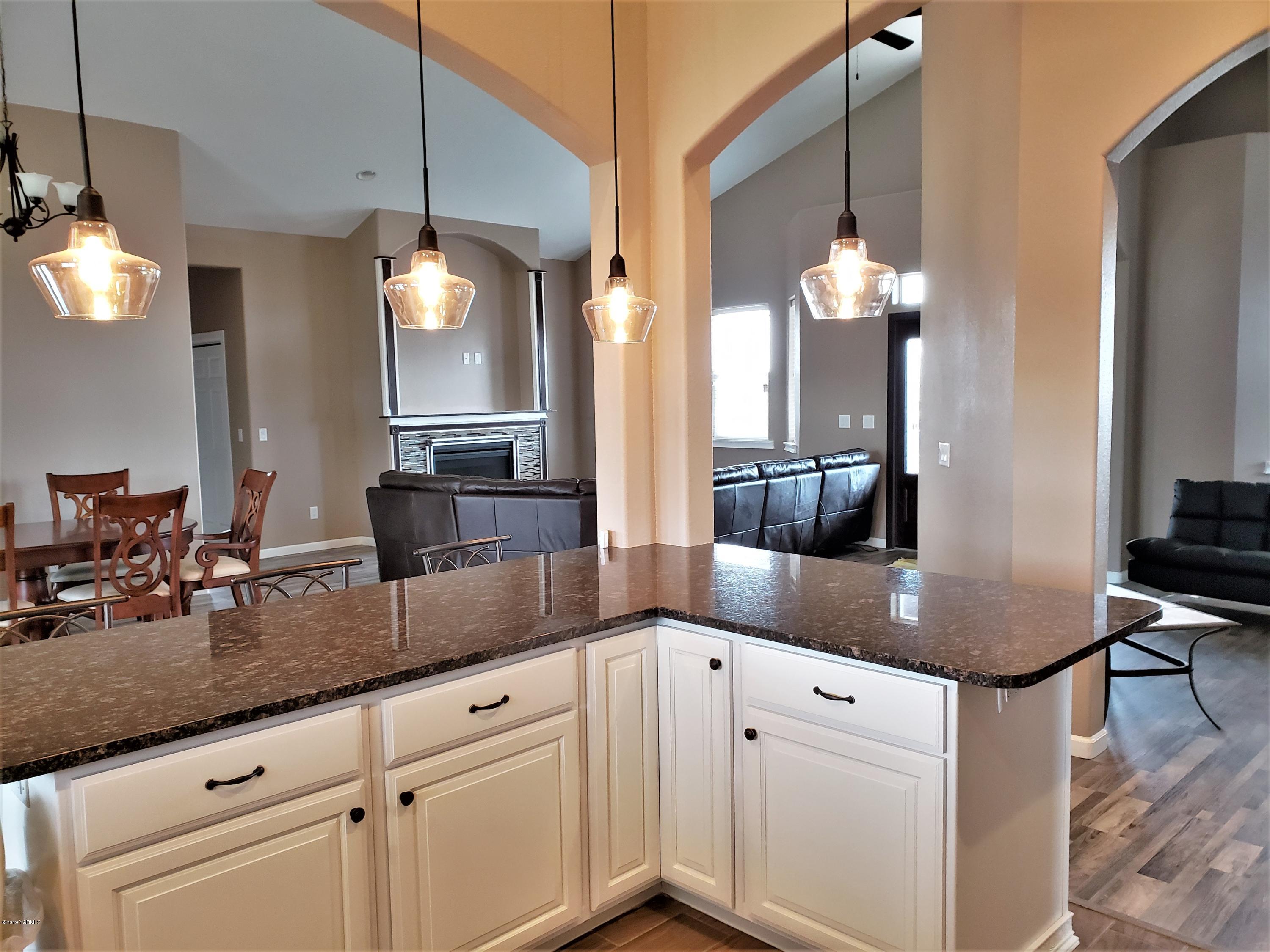 1201 Northwest Crescent Road Sunnyside, WA 98944 - Photo 2 of 35 a kitchen with kitchen island granite countertop a sink a counter space appliances and cabinets