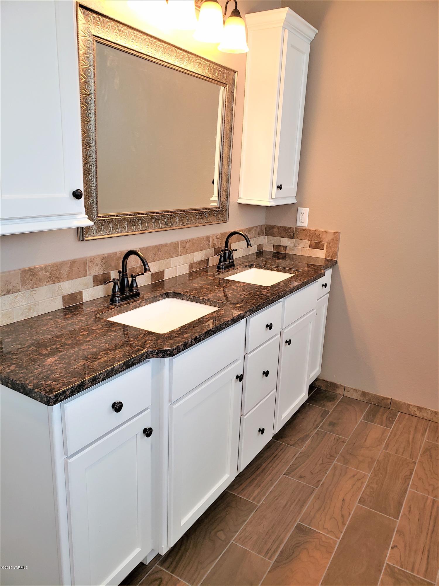 1201 Northwest Crescent Road Sunnyside, WA 98944 - Photo 11 of 35 a bathroom with a granite countertop sink and a mirror