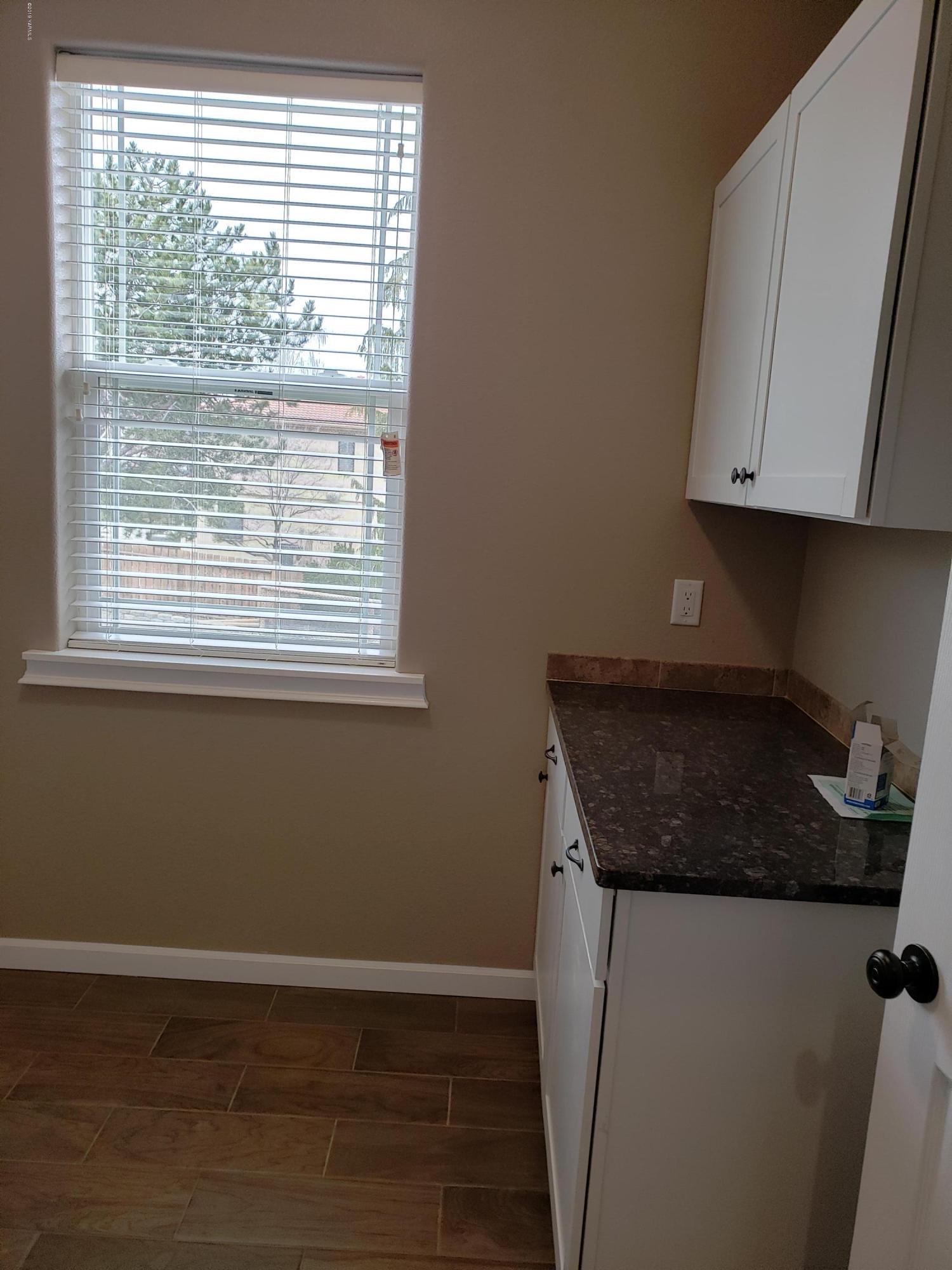 1201 Northwest Crescent Road Sunnyside, WA 98944 - Photo 21 of 35 a kitchen with granite countertop white cabinets and a window