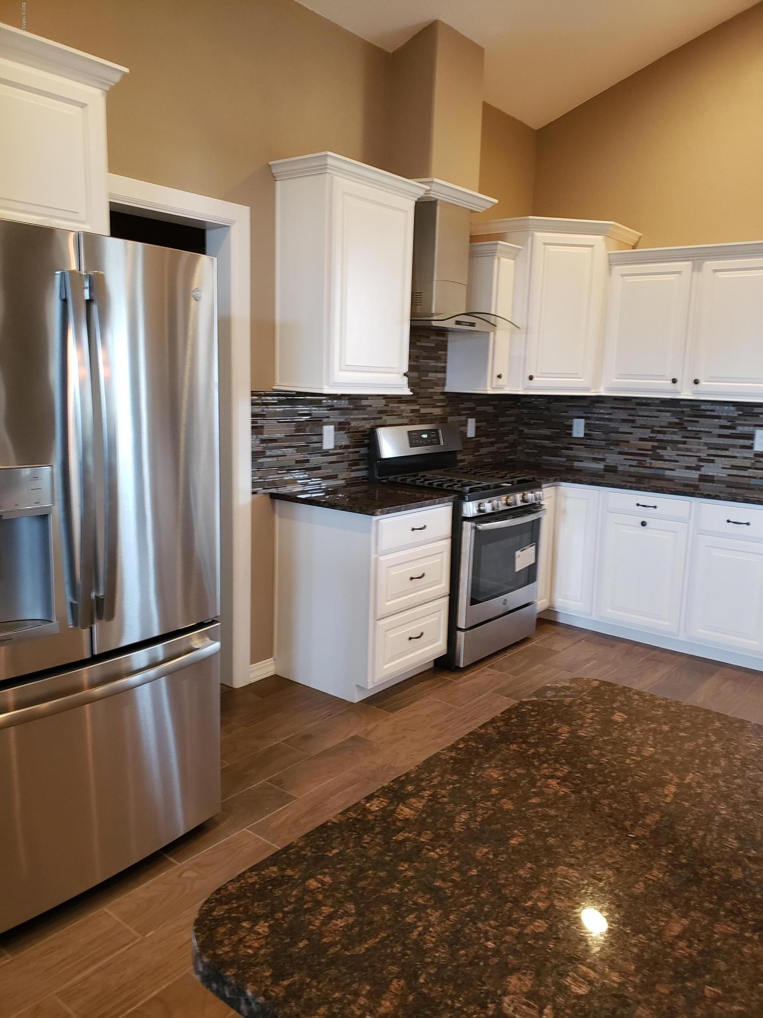 1201 Northwest Crescent Road Sunnyside, WA 98944 - Photo 8 of 35 a kitchen with stainless steel appliances granite countertop a stove a sink and a refrigerator