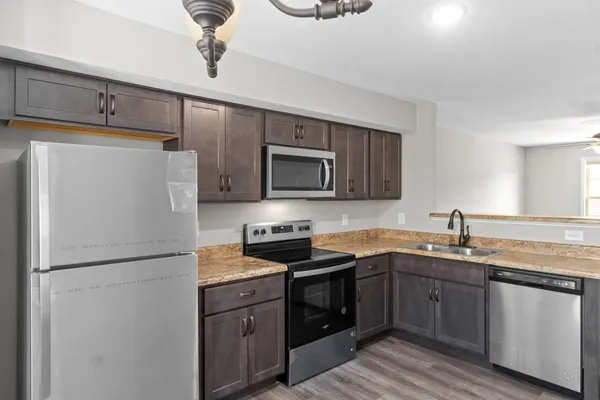 a kitchen with stainless steel appliances granite countertop a refrigerator stove a sink and dishwasher