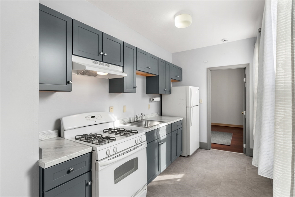 70-72 Russell Street Worcester, MA 01609 - Photo 19 of 30 a kitchen with stainless steel appliances a stove a sink and a refrigerator