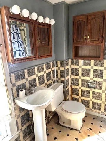 a bathroom with a sink a toilet and mirror