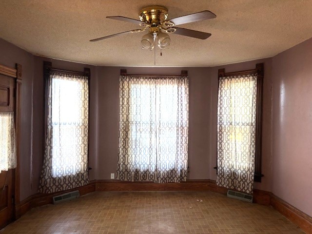 301 South Grape Street Morrison, IL 61270 - Photo 7 of 25 an empty room with a ceiling fan and windows