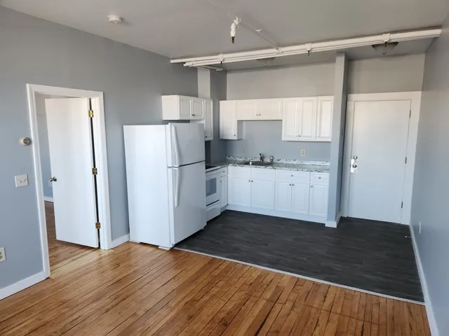 a view of a kitchen with wooden floor and electronic appliances