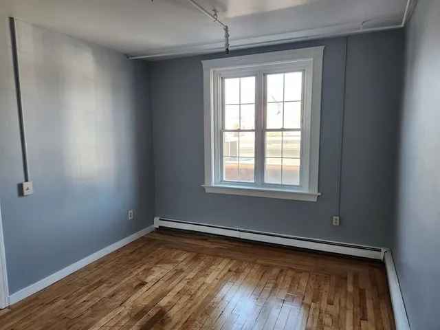 a view of a room with wooden floor and a window